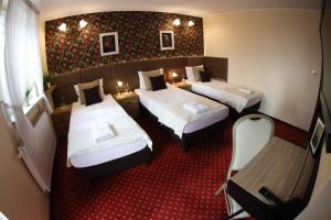 a hotel room with two beds and two lamps at Valdi Classic in Zabrze