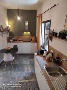 uma cozinha com um lavatório e uma mesa em Malibu em Glyfada