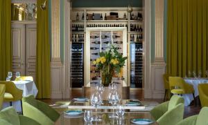 a dining room with a table with a vase of flowers at Vila Foz Hotel & SPA - member of Design Hotels in Porto