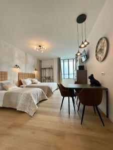 a bedroom with two beds and a table and a clock at Barirooms - Picca 24 in Bari