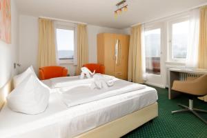una camera d'albergo con un letto con due animali di peluche di Panoramahotel Berghof a Baiersbronn