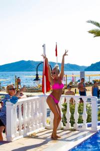 a woman in a pink bikini standing next to a pool at Fortezza Beach Resort in Hisarönü