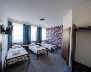 um quarto de hotel com duas camas e uma televisão em Kelman Inn Global Nowa Sól em Nowa Sól