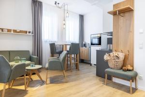 a living room with a table and chairs and a kitchen at Ferienapartments am Krusespeicher Ferienapartments am Krusespeicher 1-09 in Wismar