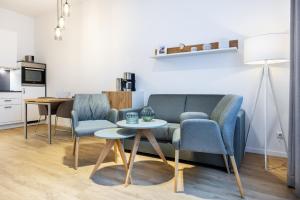 a living room with a couch and two chairs and a table at Ferienapartments am Krusespeicher Ferienapartments am Krusespeicher 2-20 in Wismar