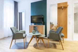 a living room with a table and chairs and a tv at Ferienapartments am Krusespeicher Ferienapartments am Krusespeicher 2-20 in Wismar
