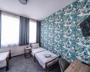 a hotel room with a bed and a blue and green wall at Kelman Inn Global Nowa Sól in Nowa Sól +81 photos