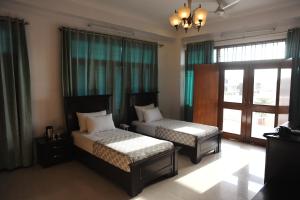 a bedroom with two beds and a chandelier at Raj Regency in Jaipur