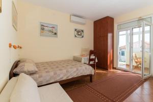a bedroom with a bed and a sliding glass door at Apartment Pulastar in Dubrovnik