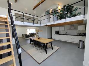 cocina y sala de estar con mesa y loft en Luxe vakantiehuis met sauna De Barn Bergen, en Bergen