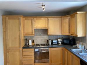 a kitchen with wooden cabinets and a stove top oven at Beautiful & Quiet Countryside Setting in Kinsale in Cork