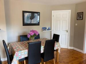 a dining room table with a vase of flowers on it at Beautiful & Quiet Countryside Setting in Kinsale in Cork