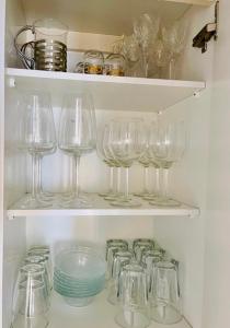 a row of wine glasses on shelves in a refrigerator at Ilona Apartments - "The City Condo" in Kotka +41 photos