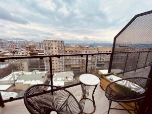 einen Balkon mit 2 Stühlen und einem Tisch auf einem Gebäude in der Unterkunft Hotel Linge in Tbilisi City