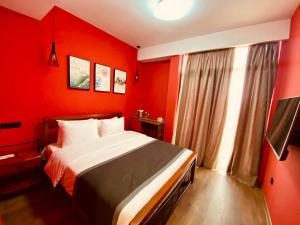 a red bedroom with a bed and a window at Hotel Linge in Tbilisi City