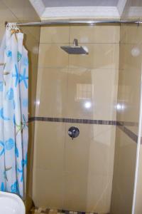 a shower with a glass door in a bathroom at Gabade Guest House in KwaDukuza