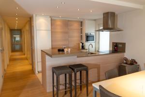 Una cocina con encimera y taburetes. en Appartement Seaview, en Koksijde