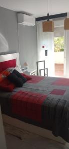 a bedroom with a bed with a red and gray blanket at Cozy Room with sunny terrace in Marbella
