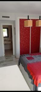 a bedroom with a bed and a red wall at Cozy Room with sunny terrace in Marbella