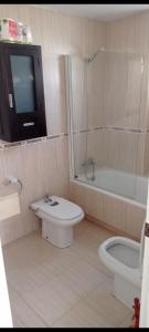 a bathroom with a toilet and a shower and a tv at Cozy Room with sunny terrace in Marbella