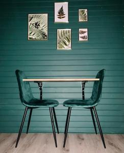 a table and two chairs against a green wall at Karczma Leśniczanka in Wielbark