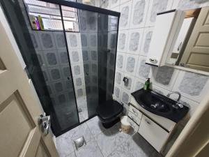 a small bathroom with a shower and a sink at Apto frente à praia, aconchegante, vista lateral pro mar! in São Vicente +37 photos