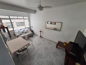 a living room with a table and a mirror on the wall at Apto frente à praia, aconchegante, vista lateral pro mar! in São Vicente