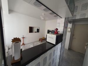 a kitchen with a black counter top and a microwave at Apto frente à praia, aconchegante, vista lateral pro mar! in São Vicente