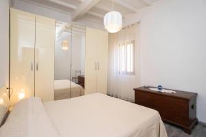 um quarto branco com uma cama e um espelho em Sulla Valle di Seccheto em Seccheto