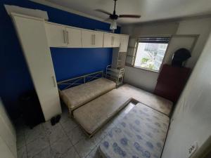 a small room with two beds and a window at Apto frente à praia, aconchegante, vista lateral pro mar! in São Vicente