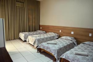a hospital room with three beds in it at Hotel Itamarati in Sao Jose do Rio Preto