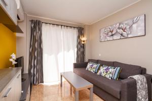 uma sala de estar com um sofá e uma janela em Apartmento Caribe Centro Casasol em Nerja