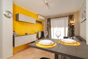 uma cozinha e sala de estar com uma mesa e parede amarela em Apartmento Caribe Centro Casasol em Nerja