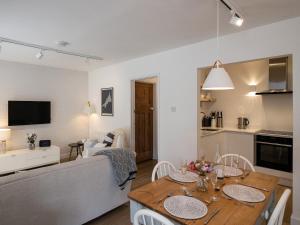 a kitchen and a living room with a table and chairs at Westward 8 in Polzeath
