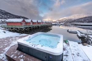 a hot tub in the snow next to a pier at Manndalen Sj&oslash;buer in Samuelsberg