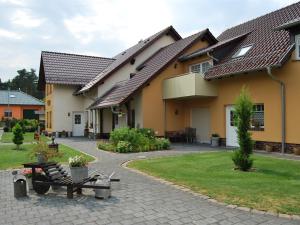 una casa con un banco en un patio en Pension + Apartments Tor zum Spreewald, en Lübben