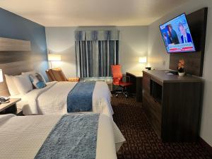 GarnettにあるGarnett Hotel & RV Parkのベッド2台、薄型テレビが備わるホテルルームです。