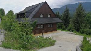 duży drewniany dom z dachem gambrel w obiekcie Drevenica Pod Vŕškom w Tierchowej