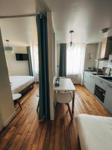 a room with a bed and a table and a kitchen at Garden Apparts Rennes Centre Gare in Rennes