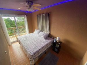 una camera da letto con un letto con un ventilatore a soffitto e una finestra di Mr, Crab Apartment a Six Huts