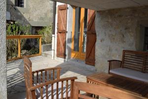um alpendre com dois bancos de madeira e uma porta em Autour du Soleil em Chindrieux