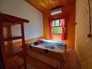 ein Schlafzimmer mit einem Bett in einem Zimmer mit einem Fenster in der Unterkunft Morada Caminho do Mar in Praia do Rosa