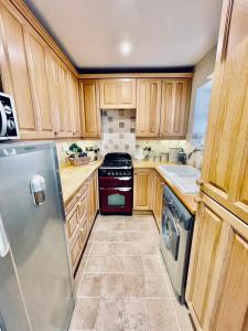 a kitchen with wooden cabinets and a stove top oven at Cotswold Chic Retreats "Jacinabox" 5 Star Chipping Campden-Parking-Garden in Chipping Campden