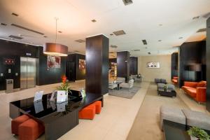 a lobby of a hotel with orange chairs and couches at Hotel CH Bucharest in Bucharest