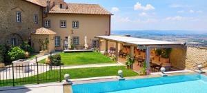 a villa with a swimming pool and a house at Monastero Di Cortona Hotel & Spa in Cortona