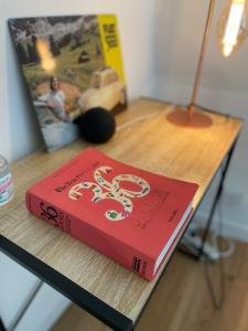 un livre rouge assis au-dessus d'une table dans l'établissement Appartement neuf et chaleureux dans Leers centre, à Leers
