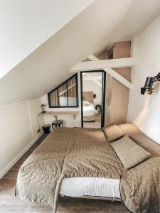 a bedroom with a large bed with a large mirror at Garden Apparts Rennes Centre Gare in Rennes