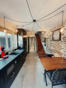 a kitchen with a clock on a brick wall at Garden Apparts Rennes Centre Gare in Rennes