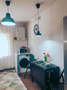 a small kitchen with a table and a microwave at Apartment One Brasov in Braşov