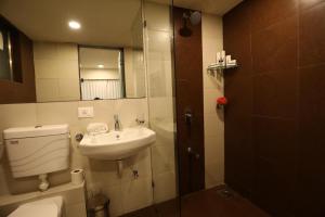 a bathroom with a sink and a toilet and a mirror at Royal treats at Rajhans Belliza Near Airport in Surat